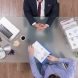 Top view of businessman analyzing financial documents discussing company strategy Top view of businessman analyzing financial documents discussing company strategy with partner during partnership meeting in startup office. Colleagues planning business strategy. Corporate agreement
